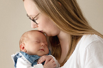 Mama küsst Baby auf dem Kopf